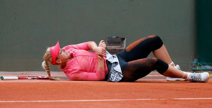 Sabine Lisicki of Germany holds her arm after falling during her women's singles match against compatriot Mona Barthel at the French Open tennis tournament at the Roland