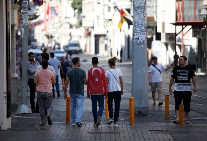 Lidé procházejí jednou z ulic blízko Taksimského náměstí v Istanbulu ráno po neúspěšném pokusu o vojenský převrat v Turecku.