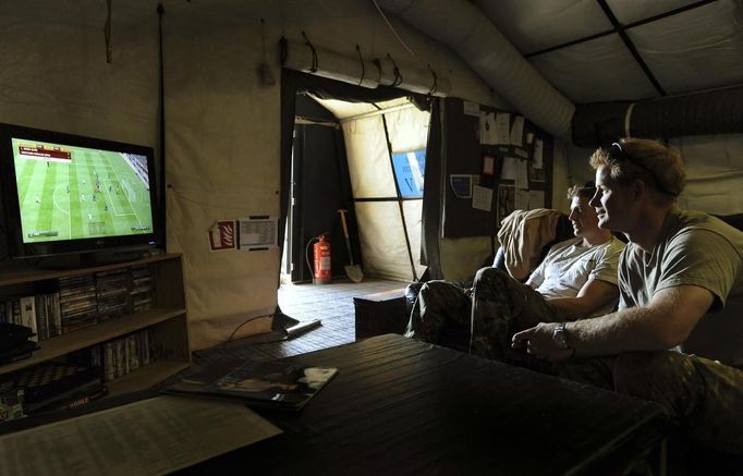 Britain's Prince Harry (R) plays a computer soccer game with fellow Apache pilot Captain Simon Beattie at Camp Bastion, southern Afghanistan in this photograph taken November 3, 2012, and released January 21, 2013. The Prince, who is serving as a pilot/gunner with 662 Squadron Army Air Corps, is on a posting to Afghanistan that runs from September 2012 to January 2013. Photograph taken November 3, 2012. REUTERS/John Stillwell/Pool (AFGHANISTAN - Tags: MILITARY POLITICS SOCIETY MEDIA ROYALS CONFLICT) Published: Led. 21, 2013, 7:46 odp.