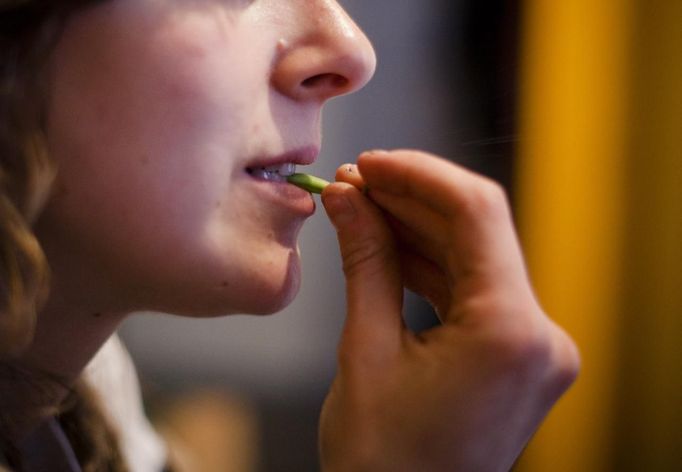 Robin Pickell, a 'freegan', eats a green bean that was scavenged in Vancouver, British Columbia April 11, 2012. A 'Freegan' is someone who gathers edible food from the garbage bins of grocery stores or food stands that would otherwise have been thrown away. Freegans aim to spend little or no money purchasing food and other goods, not through financial need but to try to address issues of over-consumption and excess. Picture taken April 11, 2012. REUTERS/Ben Nelms (CANADA - Tags: SOCIETY) ATTENTION EDITORS PICTURE 07 OF 21 FOR PACKAGE 'DUMPSTER DIVING FOR FOOD' Published: Kvě. 15, 2012, 11:58 dop.