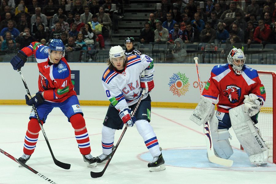 Hokejisté Lva Praha Martin Škoula (vlevo) a Tomáš Pöpperle brání Viktora Tichonova v utkání KHL proti SKA Petrohradu.