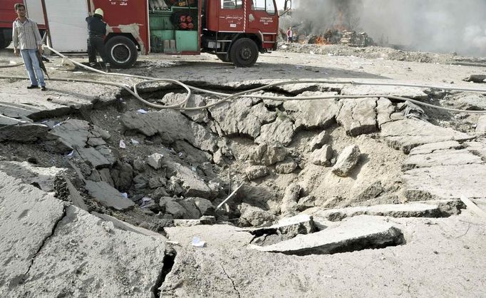 A Syrian security official stands near a crater at the site of an explosion in Damascus May 10, 2012. Dozens of people were killed or wounded in two "terrorist explosions" which struck a southern district of the Syrian capital Damascus on Thursday, state television said. REUTERS/Sana/Handout (SYRIA - Tags: CIVIL UNREST POLITICS) FOR EDITORIAL USE ONLY. NOT FOR SALE FOR MARKETING OR ADVERTISING CAMPAIGNS. THIS IMAGE HAS BEEN SUPPLIED BY A THIRD PARTY. IT IS DISTRIBUTED, EXACTLY AS RECEIVED BY REUTERS, AS A SERVICE TO CLIENTS Published: Kvě. 10, 2012, 7:07 dop.