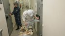 A security officer stands next to an inmate serving dinner to prisoners, inside a zone where especially strict conditions are imposed at a high-security male prison camp outside Russia's Siberian city of Krasnoyarsk May 14, 2013. High-security male prison camp number 17 is intended to house male inmates who are serving a sentence for the first time, and have been convicted for serious crimes. Prisoners at the facility work in wood and metal processing shops, manufacture furniture, sew clothes and do other kinds of work. They can also take part in educational, sport and cultural programs. Picture taken May 14, 2013. REUTERS/Ilya Naymushin (RUSSIA - Tags: CRIME LAW SOCIETY) ATTENTION EDITORS: PICTURE 12 OF 29 FOR PACKAGE 'INSIDE SIBERIA'S PRISONS' SEARCH 'ILYA PRISON' FOR ALL IMAGES Published: Čer. 19, 2013, 10:03 dop.