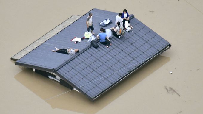 Trosečníci na střeše domu v jedné z nejhůře postižených oblastí, jíž je prefektura Okajama.