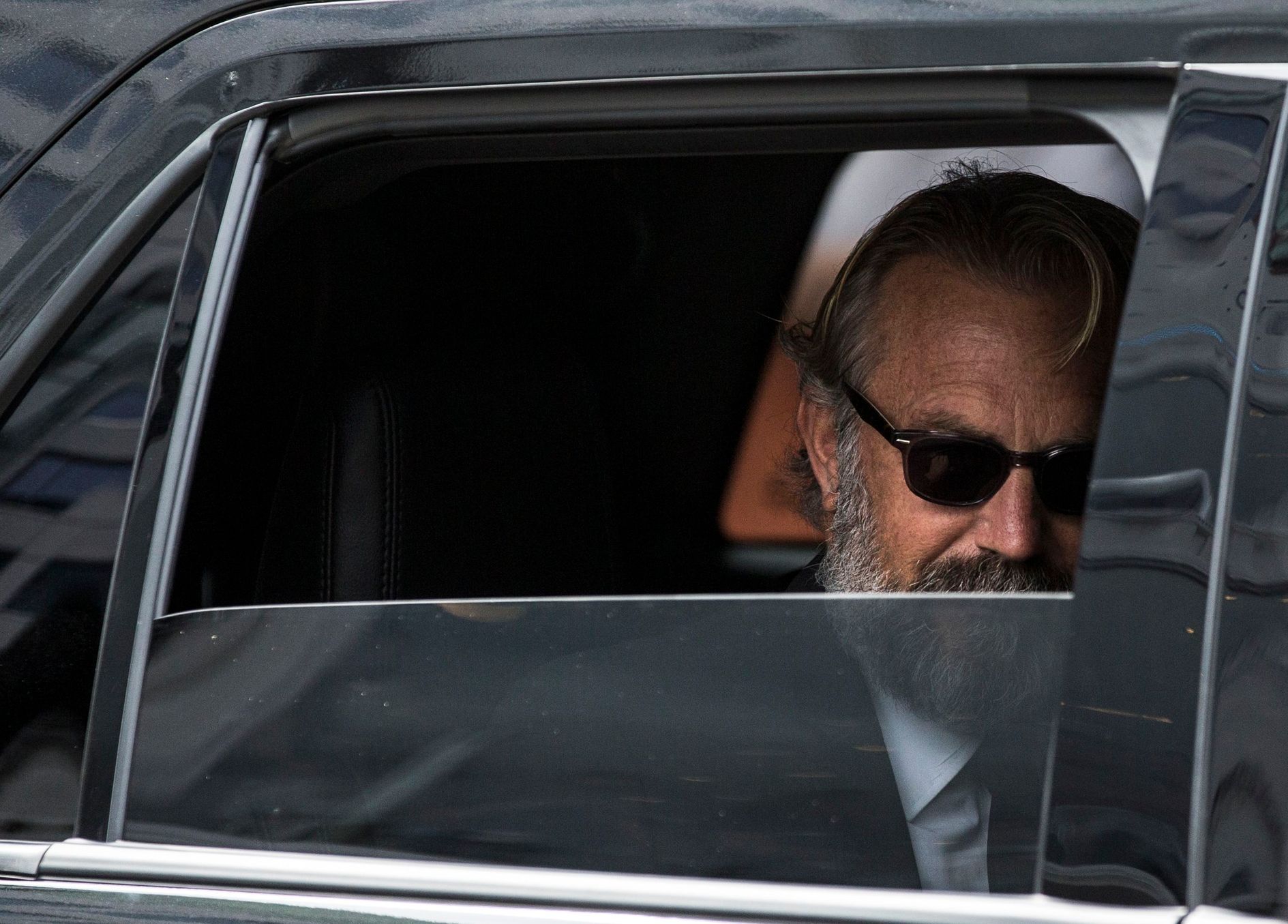 Kevin Costner looks out the window of his car as he arrives for the &quot;Black and White&quot; gala at the Toronto International Film Festival in Toronto