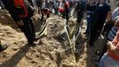 Civil defense members try to dig out a car buried under the sand after an Israeli air strike in the northern Gaza Strip November 15, 2012. A Hamas rocket killed three Israelis north of the Gaza Strip on Thursday, drawing the first blood from Israel as the Palestinian death toll rose to 13 and a military showdown lurched closer to all-out war with an invasion of the enclave. REUTERS/Mohammed Salem (GAZA - Tags: CIVIL UNREST MILITARY POLITICS TRANSPORT) Published: Lis. 15, 2012, 1:29 odp.