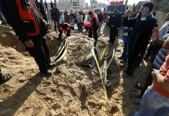 Civil defense members try to dig out a car buried under the sand after an Israeli air strike in the northern Gaza Strip November 15, 2012. A Hamas rocket killed three Israelis north of the Gaza Strip on Thursday, drawing the first blood from Israel as the Palestinian death toll rose to 13 and a military showdown lurched closer to all-out war with an invasion of the enclave. REUTERS/Mohammed Salem (GAZA - Tags: CIVIL UNREST MILITARY POLITICS TRANSPORT) Published: Lis. 15, 2012, 1:29 odp.