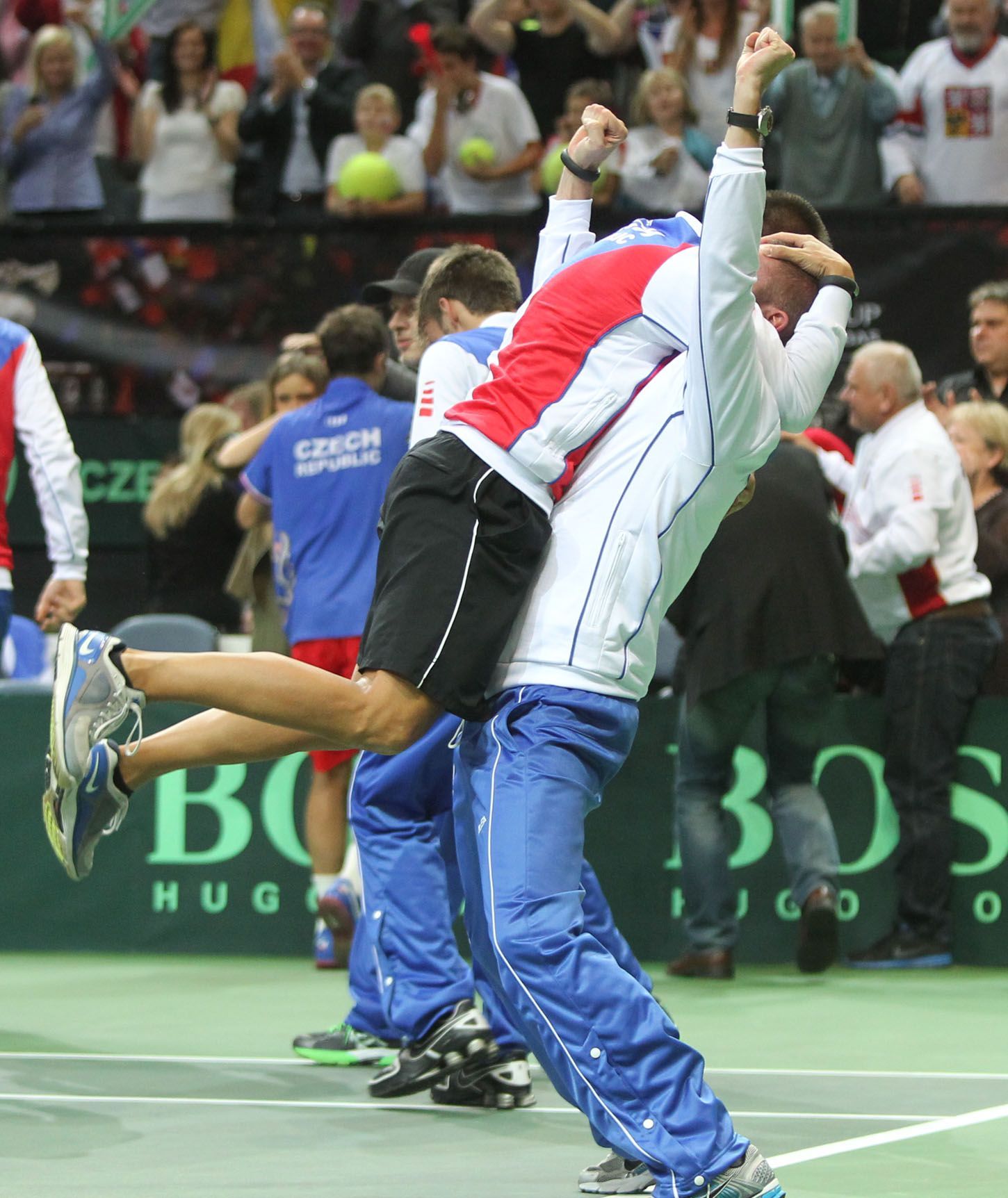 Čeští tenisté se radují z vítězství ve finále Davis Cupu 2012 proti Španělsku.