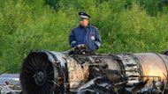 Policista hlídkuje u trosek spadlého stroje.