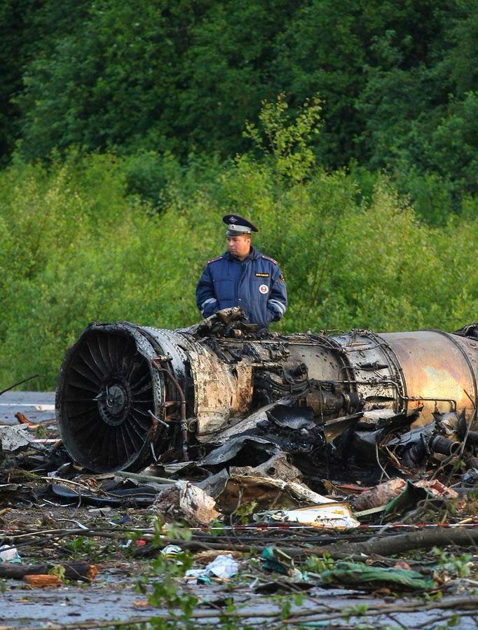 Policista hlídkuje u trosek spadlého stroje; k letišti v Petrozavodsku zbývá ještě kilometr.