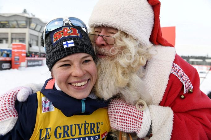 Second-placed Krista Parmakoski of Finland gets a kiss from a man dressed as Santa Claus after ladies' Cross Country 10 km Classic at FIS Ruka Nordic 2016 World Cup sea