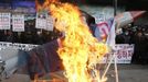 Anti-North Korean protesters burn a mock North Korean missile, its flag and an effigy of the North's leader Kim Jong-Un during a protest blaming the North's rocket launch in central Seoul December 12, 2012. North Korea successfully launched a rocket on Wednesday, boosting the credentials of its new leader and stepping up the threat the isolated and impoverished state poses to its opponents. The rocket, which North Korea says put a weather satellite into orbit, has been labelled by the United States, South Korea and Japan as a test of technology that could one day deliver a nuclear warhead capable of hitting targets as far as the continental United States. REUTERS/Lee Jae-Won (SOUTH KOREA - Tags: MILITARY POLITICS CIVIL UNREST)