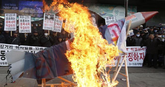 Anti-North Korean protesters burn a mock North Korean missile, its flag and an effigy of the North's leader Kim Jong-Un during a protest blaming the North's rocket launch in central Seoul December 12, 2012. North Korea successfully launched a rocket on Wednesday, boosting the credentials of its new leader and stepping up the threat the isolated and impoverished state poses to its opponents. The rocket, which North Korea says put a weather satellite into orbit, has been labelled by the United States, South Korea and Japan as a test of technology that could one day deliver a nuclear warhead capable of hitting targets as far as the continental United States. REUTERS/Lee Jae-Won (SOUTH KOREA - Tags: MILITARY POLITICS CIVIL UNREST)