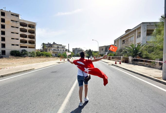 Žena s tureckou vlajkou se prochází Varošou.