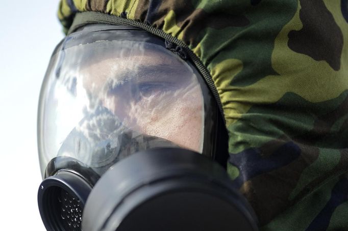 A Brazilian army soldier wearing a chemical suit participates in an anti-terror simulation exercise as part of the preparation for the upcoming 2013 FIFA Confederations Cup in Brasilia. May 22, 2013. About 100 soldiers took part in the exercise which include preventive strikes against chemical, biological and radiological weapons conducted around Mane Garrincha National Stadium, according to an official statement. REUTERS/Ueslei Marcelino (BRAZIL - Tags: SPORT SOCCER MILITARY) Published: Kvě. 22, 2013, 9:32 odp.