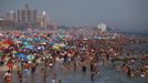 People crowd at the beach at Coney Island in the Brooklyn borough of New York June 30, 2012. About 3.9 million homes and businesses were without power on Saturday amid a record heat wave in the eastern United States after deadly thunderstorms downed power lines from Indiana to New Jersey. REUTERS/Eric Thayer (UNITED STATES - Tags: ENVIRONMENT SOCIETY) Published: Čer. 30, 2012, 8:34 odp.