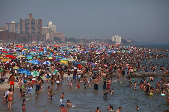 People crowd at the beach at Coney Island in the Brooklyn borough of New York June 30, 2012. About 3.9 million homes and businesses were without power on Saturday amid a record heat wave in the eastern United States after deadly thunderstorms downed power lines from Indiana to New Jersey. REUTERS/Eric Thayer (UNITED STATES - Tags: ENVIRONMENT SOCIETY) Published: Čer. 30, 2012, 8:34 odp.