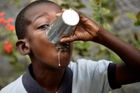 Žízeň v Port-au-Prince. Chlapec z Haiti pije mléko před začátkem školy.