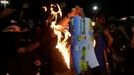 Demonstrators burn a 2014 World Cup sticker album during a protest against the 2014 World Cup in Rio de Janeiro May 15, 2014. Brazilians opposed to the World Cup and the