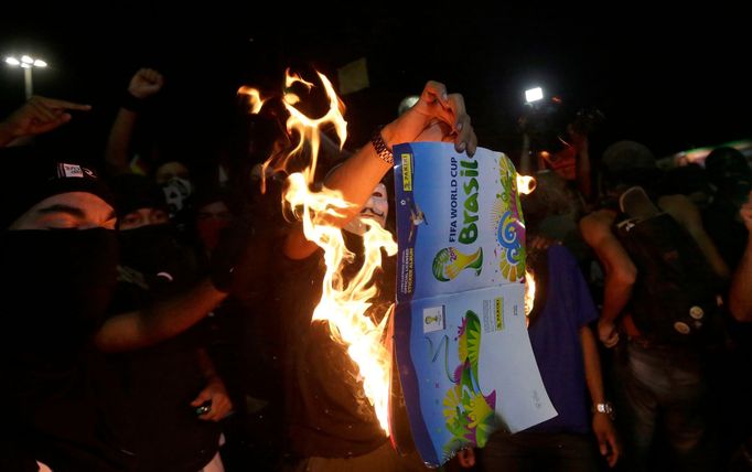 Demonstrators burn a 2014 World Cup sticker album during a protest against the 2014 World Cup in Rio de Janeiro May 15, 2014. Brazilians opposed to the World Cup and the