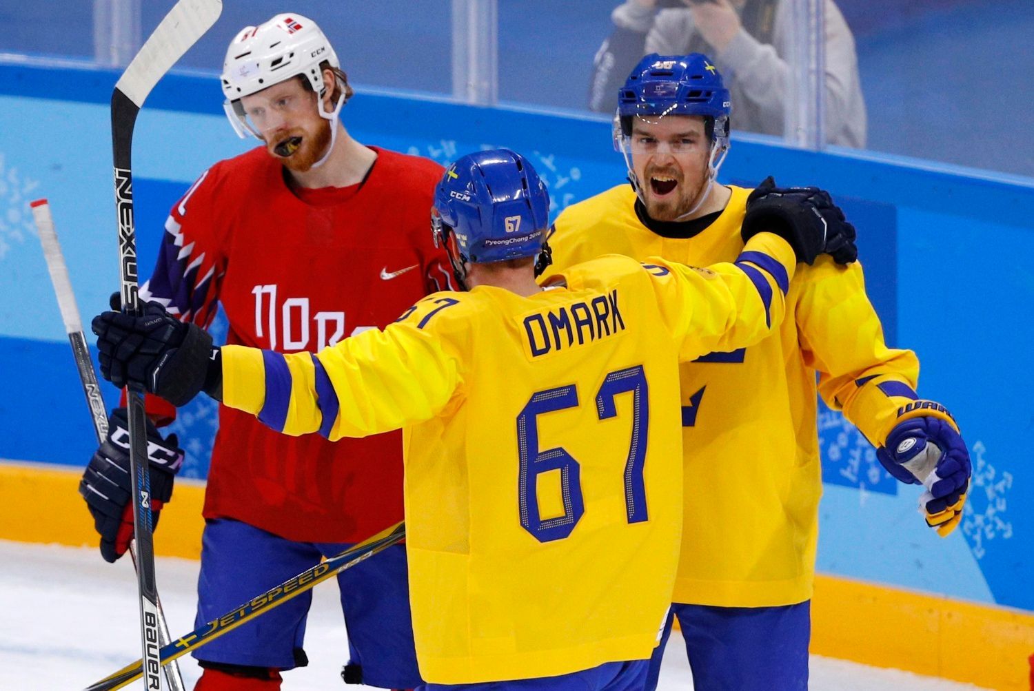 Švédští hokejisté Linus Omark a Anton Lander slaví gól v síti Norska.