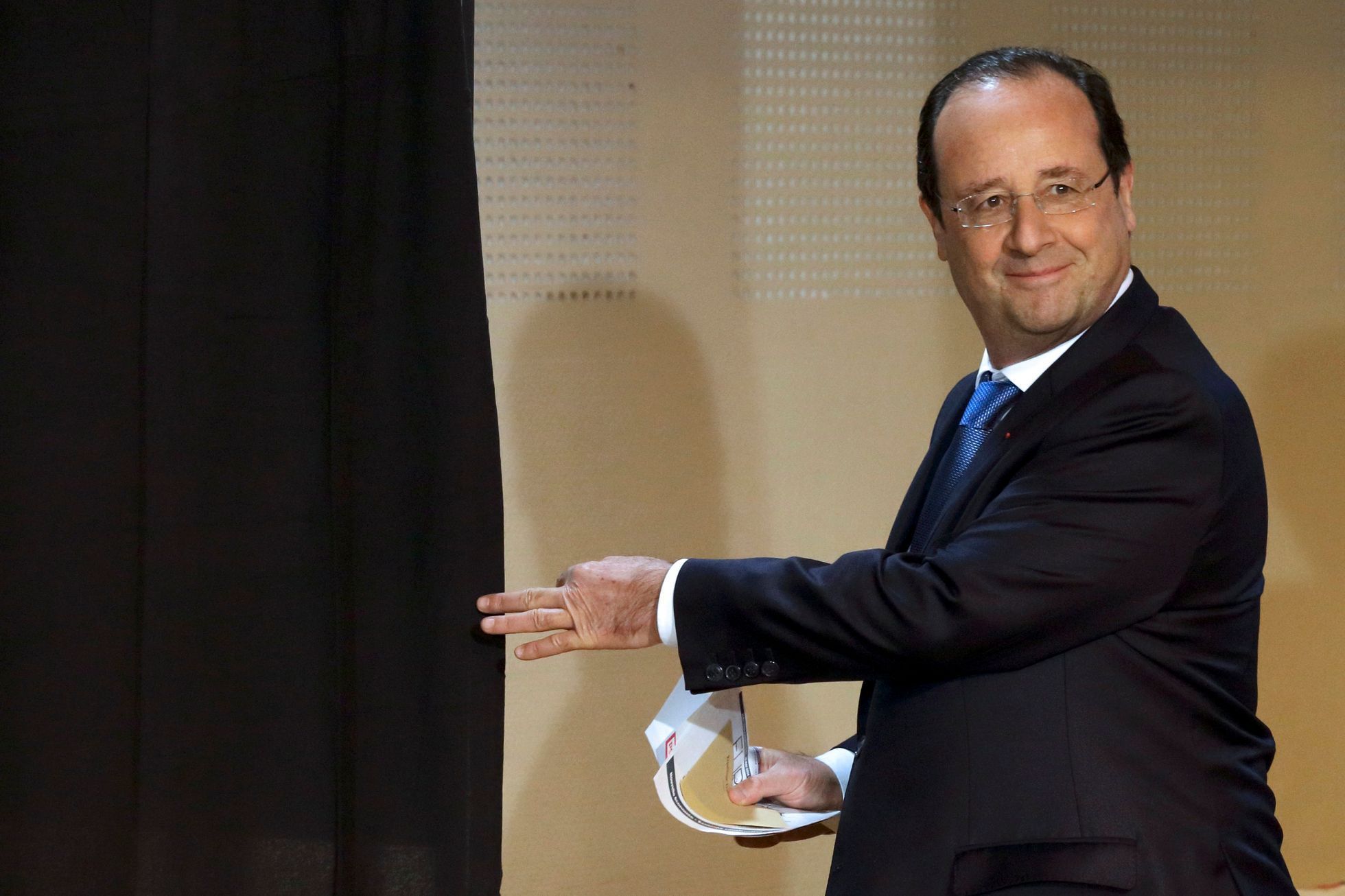 France's President Francois Hollande enters the polling booth before casting his ballot in the European Parliament election in Tulle