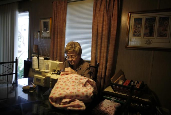 June Manning, 84, sews in her trailer home in which she has lived for 18 years, in Village Trailer Park in Santa Monica, California July 12, 2012. Developer Marc Luzzatto wants to relocate residents from the trailer park to make way for nearly 500 residences, office space, stores, cafes and yoga studios, close to where a light rail line is being built to connect downtown Los Angeles to the ocean. Village Trailer Park was built in 1951, and 90 percent of its residents are elderly, disabled or both, according to the Legal Aid Society. Many have lived there for decades in old trailers which they bought. The property is valued at as much as $30 million, according the LA Times. Picture taken July 12, 2012. REUTERS/Lucy Nicholson (UNITED STATES - Tags: POLITICS REAL ESTATE BUSINESS SOCIETY) Published: Čec. 14, 2012, 6:32 dop.