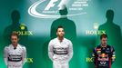 Mercedes Formula One driver Lewis Hamilton (C) of Britain waits to receive the trophy after winning the Japanese F1 Grand Prix at the Suzuka Circuit October 5, 2014. On l