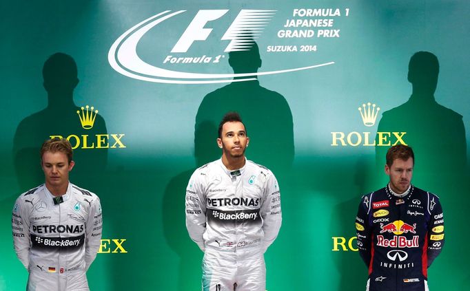 Mercedes Formula One driver Lewis Hamilton (C) of Britain waits to receive the trophy after winning the Japanese F1 Grand Prix at the Suzuka Circuit October 5, 2014. On l