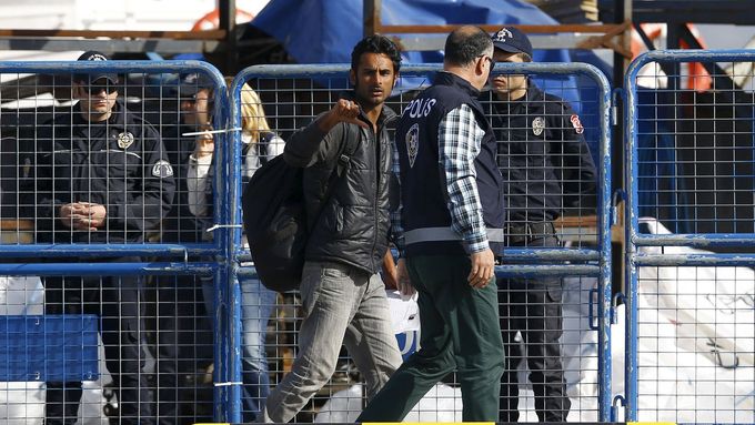 Policie eskortuje v tureckém přístavu Dikili migranta, který byl přivezen trajektem z Řecka