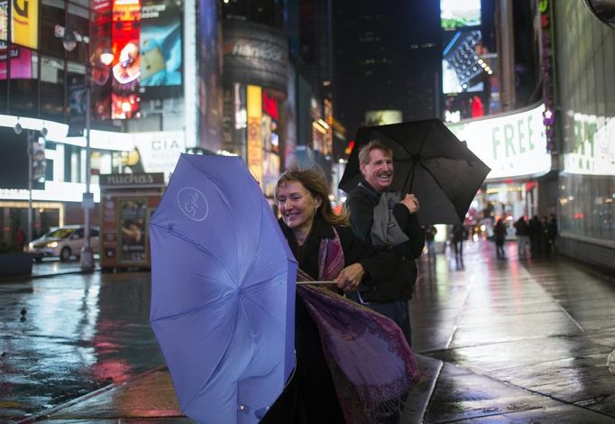 A visitor from New Mexico tries to hold onto her umbrella while taking pictures in Times Square in New York October 29, 2012. As Hurricane Sandy aimed straight for them, promising to hammer the place they live with lashing winds and extensive flooding, New Yorkers seemed to be all about nonchalance on Monday morning - an attitude that didn't last into the afternoon. REUTERS/Adrees Latif (UNITES STATES - Tags: ENVIRONMENT DISASTER SOCIETY) Published: Říj. 30, 2012, 12:35 dop.