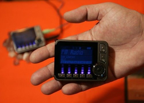 Muž drží rádio propojující se s internetem, schopné naladit jakoukoliv stanici, která vysílá po netu.