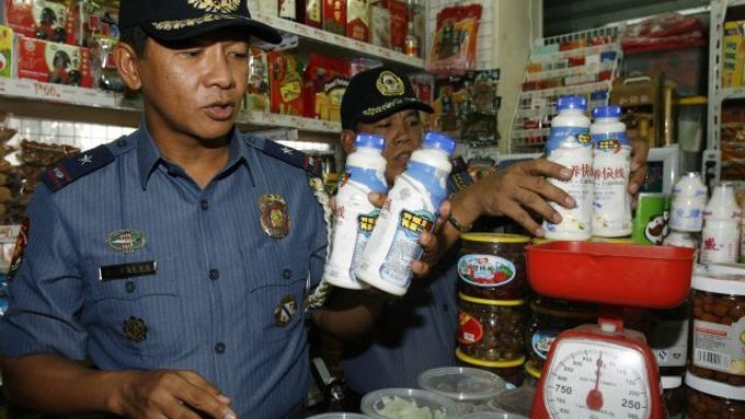 Policisté odstraňují čínské mléko z obchodu ve filipínské Manile.