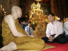 Premiér Šinavatra rozmlouvá s mnichem v klášteře Bovorn Rachanivej. Šinavatra je známý tím, že se často řídí podle předpovědí astrologů.