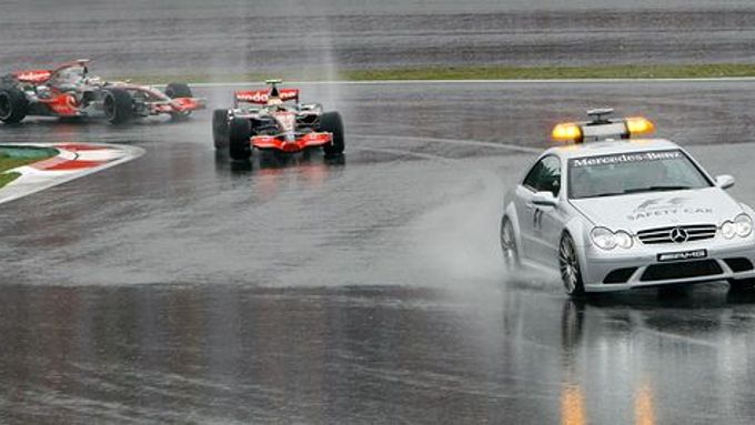 Lewis Hamilton (uprostřed) a Fernando Alonso z McLarenu jedou za zaváděcím vozidlem v úvodu Velké ceny Japonska.