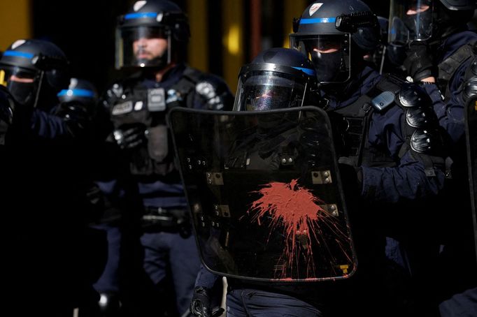 Na štítu francouzského pořádkového policisty je vidět skvrna od barvy během střetů s protestujícími na demonstraci v Paříži.