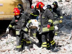 Kolegové nešťastného hasiče odnášejí tělo dcery, nepřežila ničivé zemětřesení, které okolí L´Aquily zasáhlo.