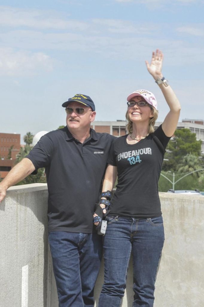 Former U.S. Congresswoman Gabrielle Giffords and her husband Mark Kelly, the retired astronaut who commanded space shuttle Endeavour's final flight on his last mission in late May 2011, watch Endeavour and its carrier jet making a flyover over Tucson, Arizona, September 20, 2012 in this handout image released to Reuters. Giffords, still recuperating from a gunshot wound to the head suffered in an attempt on her life last year, watched the flyover from the roof of a Tucson parking garage with her husband and mother, according to former aide C.J. Karamargin, who joined them. REUTERS/Mark Kelly/Handout (UNITED STATES - Tags: SCIENCE TECHNOLOGY POLITICS) NO SALES. NO ARCHIVES. FOR EDITORIAL USE ONLY. NOT FOR SALE FOR MARKETING OR ADVERTISING CAMPAIGNS. THIS IMAGE HAS BEEN SUPPLIED BY A THIRD PARTY. IT IS DISTRIBUTED, EXACTLY AS RECEIVED BY REUTERS, AS A SERVICE TO CLIENTS Published: Zář. 21, 2012, 12:54 dop.