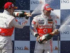 Fernando Alonso sprchuje šampaňským svého parťáka z McLarenu Lewise Hamiltona na stupních vítězů Velké ceny Austrálie.