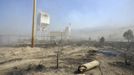 A telephone pole, damaged from the so-called Dump Fire, smoulders on the ground outside of an explosives plant near Saratoga Springs, Utah, June 23, 2012. A raging Utah brush fire ignited by target shooting in dry grass has forced some 8,000 people from their homes in two small communities since June 22 as high winds fanned flames toward a nearby explosives factory, authorities said. REUTERS/Jeff McGrath (UNITED STATES - Tags: ENVIRONMENT DISASTER) Published: Čer. 24, 2012, 2:02 dop.