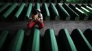 A Bosnian Muslim man cries near coffins prepared for a mass burial at the Memorial Center in Potocari, near Srebrenica July 9, 2012. The bodies of 520 recently identified victims of the Srebrenica massacre will be buried on July 11, the anniversary of the massacre when Bosnian Serb forces commanded by Ratko Mladic slaughtered 8,000 Muslim men and boys and buried them in mass graves, in Europe's worst massacre since World War Two. REUTERS/Dado Ruvic (BOSNIA CIVIL UNREST POLITICS - Tags: ANNIVERSARY POLITICS CONFLICT TPX IMAGES OF THE DAY) Published: Čec. 9, 2012, 5:48 odp.