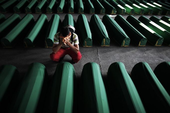 A Bosnian Muslim man cries near coffins prepared for a mass burial at the Memorial Center in Potocari, near Srebrenica July 9, 2012. The bodies of 520 recently identified victims of the Srebrenica massacre will be buried on July 11, the anniversary of the massacre when Bosnian Serb forces commanded by Ratko Mladic slaughtered 8,000 Muslim men and boys and buried them in mass graves, in Europe's worst massacre since World War Two. REUTERS/Dado Ruvic (BOSNIA CIVIL UNREST POLITICS - Tags: ANNIVERSARY POLITICS CONFLICT TPX IMAGES OF THE DAY) Published: Čec. 9, 2012, 5:48 odp.