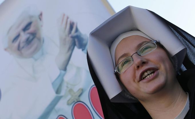 A nun waits in a packed Saint Peter's Square where Pope Benedict XVI holds his last general audience, at the Vatican February 27, 2013. The weekly event which would normally be held in a vast auditorium in winter, but has been moved outdoors to St. Peter's Square so more people can attend. The pope has two days left before he takes the historic step of becoming the first pontiff in some six centuries to step down instead of ruling for life. REUTERS/Alesandro Bianchi (VATICAN - Tags: RELIGION SOCIETY) Published: Úno. 27, 2013, 10:04 dop.