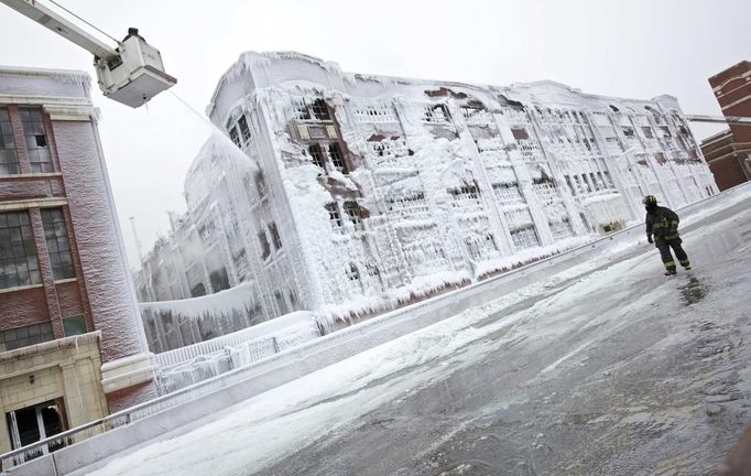 Firefighters spray down hot spots on an ice covered warehouse that caught fire Tuesday night in Chicago January 23, 2013. Fire department officials said it is the biggest fire the department has had to battle in years and one-third of all Chicago firefighters were on the scene at one point or another trying to put out the flames. An Arctic blast continues to gripped the U.S. Midwest and Northeast Wednesday, with at least three deaths linked to the frigid weather, and fierce winds made some locations feel as cold as 50 degrees below zero Fahrenheit. (minus 46 degrees Celsius) REUTERS/John Gress (UNITED STATES - Tags: DISASTER ENVIRONMENT) Published: Led. 23, 2013, 4:42 odp.