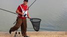 Mark Bartlett of England carries a carp he caught during the 14th Carpfishing World Championship in Corbu village, 310 km (192 miles) east of Bucharest, September 29, 2012. REUTERS/Radu Sigheti (ROMANIA - Tags: SOCIETY) Published: Zář. 29, 2012, 4:37 odp.