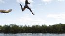 A Yawalapiti boy jumps into the Xingu River in the Xingu National Park, Mato Grosso State, May 8, 2012. In August the Yawalapiti tribe will hold the Quarup, which is a ritual held over several days to honour in death a person of great importance to them. This year the Quarup will be honouring two people - a Yawalapiti Indian who they consider a great leader, and Darcy Ribeiro, a well-known author, anthropologist and politician known for focusing on the relationship between native peoples and education in Brazil. Picture taken May 8, 2012. REUTERS/Ueslei Marcelino (BRAZIL - Tags: SOCIETY ENVIRONMENT) ATTENTION EDITORS - PICTURE 02 OF 28 FOR PACKAGE 'LIFE WITH THE YAWALAPITI TRIBE' Published: Kvě. 15, 2012, 5:08 odp.