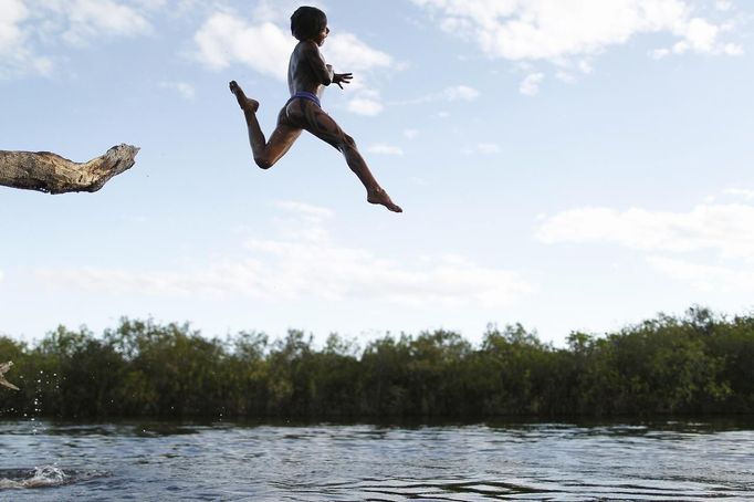 A Yawalapiti boy jumps into the Xingu River in the Xingu National Park, Mato Grosso State, May 8, 2012. In August the Yawalapiti tribe will hold the Quarup, which is a ritual held over several days to honour in death a person of great importance to them. This year the Quarup will be honouring two people - a Yawalapiti Indian who they consider a great leader, and Darcy Ribeiro, a well-known author, anthropologist and politician known for focusing on the relationship between native peoples and education in Brazil. Picture taken May 8, 2012. REUTERS/Ueslei Marcelino (BRAZIL - Tags: SOCIETY ENVIRONMENT) ATTENTION EDITORS - PICTURE 02 OF 28 FOR PACKAGE 'LIFE WITH THE YAWALAPITI TRIBE' Published: Kvě. 15, 2012, 5:08 odp.