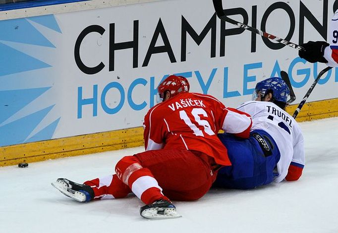 Jíří Vašíček (vlevo, HC Slavia Praha) a Jean-Guy Trudel (vpravo, ZSC Lions Curych) během urputné hry o puk u mantinelu za brankou hostů.