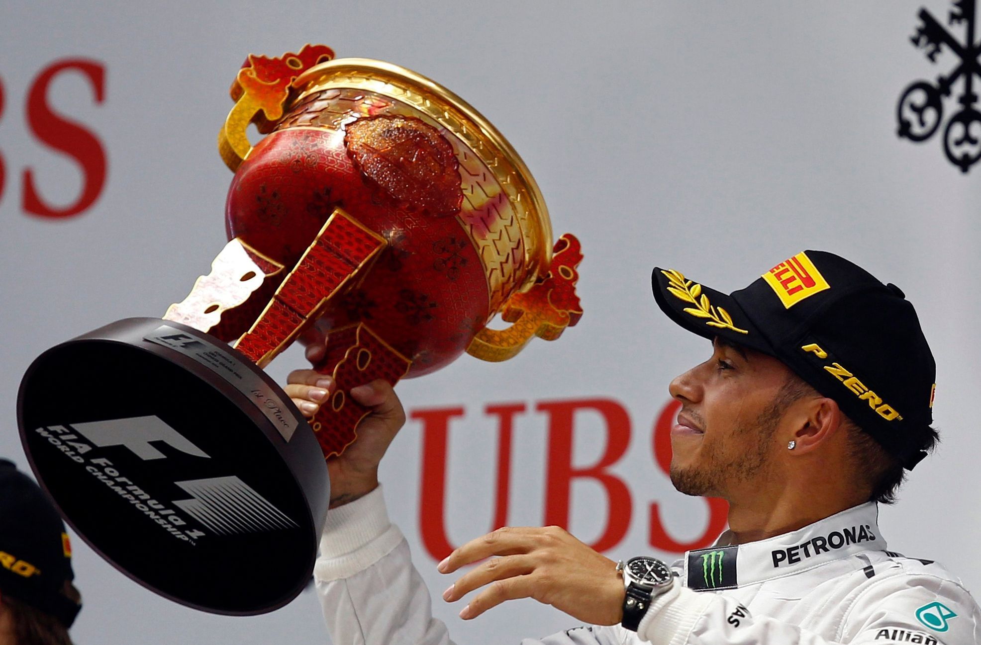Mercedes Formula One driver Lewis Hamilton of Britain waves his trophy on the winners' podium, after winning the Chinese F1 Grand Prix at the Shanghai International circuit