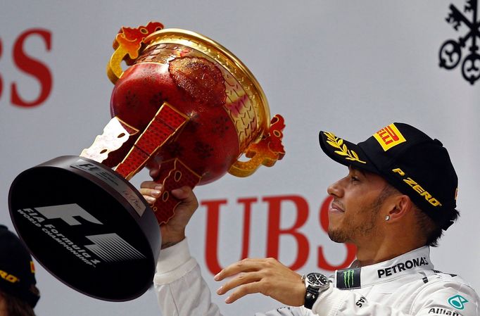 Mercedes Formula One driver Lewis Hamilton of Britain waves his trophy on the winners' podium, after winning the Chinese F1 Grand Prix at the Shanghai International circu